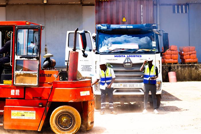 Forklift handling alongside a loaded trailer
